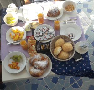 - une table avec des assiettes de pâtisseries et de nourriture dans l'établissement B&B Villa Passiaturo, à Peschici
