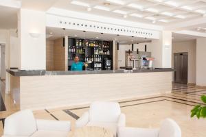 a man standing in front of a bar at Grupotel Club Menorca in Son Xoriguer