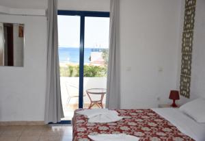 a bedroom with a bed and a view of the ocean at Kiotari Beach Apartments in Kiotari