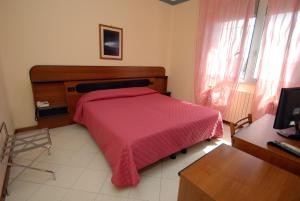 a bedroom with a bed and a dresser at Hotel Baia Del Sorriso in Castiglioncello
