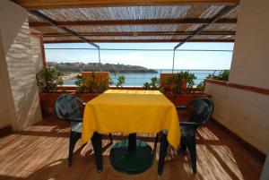 una mesa amarilla y sillas en el balcón en Hotel Baia Del Sorriso, en Castiglioncello