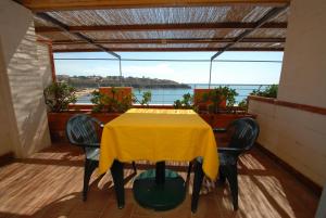 カスティリョンチェッロにあるHotel Baia Del Sorrisoの黄色のテーブルと椅子が備わるバルコニー