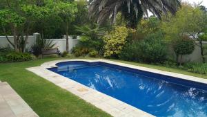 a small blue swimming pool in a yard at Cherry Berry Guest House in George