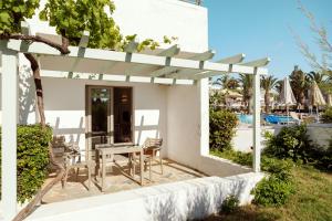 un patio con mesa y sillas junto a una piscina en Sol Marina Beach Crete en Gouves