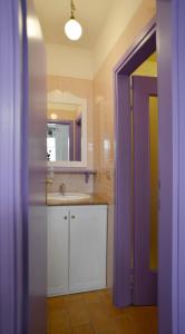 ein Badezimmer mit einem Waschbecken und einer lila Tür in der Unterkunft Casetta Liberty in Grado