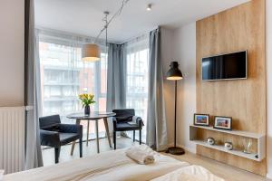 a bedroom with a bed and a table with chairs at Apartamenty Apartinfo Chmielna Park in Gdańsk