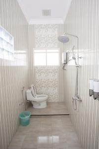 ein Bad mit einem WC und einem Fenster in der Unterkunft Huis Van Gustafine Floor 2 in Malang