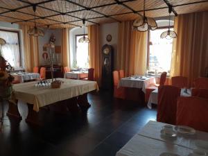 a dining room with two tables and a clock at Pension und Restaurant Die Burg in Ehrenfriedersdorf