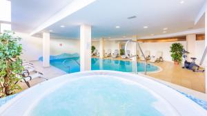 a large indoor pool with a hot tub in a hotel at Hotel Julius Payer in Solda