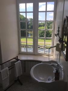 La salle de bains est pourvue d'un lavabo et d'une fenêtre. dans l'établissement Château de la Motte Beaumanoir, à Pleugueneuc