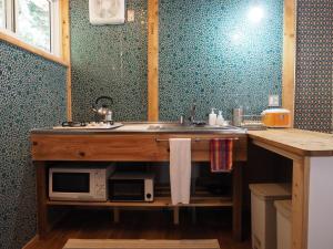 a kitchen counter with a sink and a microwave at Oku Cottage - walk to Ohama Beach - Max 4 ppl in Shimoda