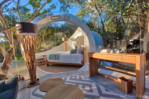 a bedroom with a bed and a table and a mirror at Bubble Lodge Ile aux Cerfs Island in Ile aux Cerfs