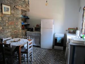 uma cozinha com uma mesa e um frigorífico branco em Fig Leaf House em Elounda