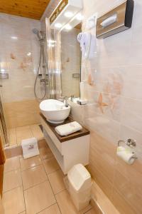 a bathroom with a sink and a shower and a toilet at Tinódi Fogadó in Sárvár