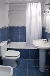 een badkamer met een toilet, een wastafel en een bad bij Ático con amplia terraza Nautilus II in Luanco