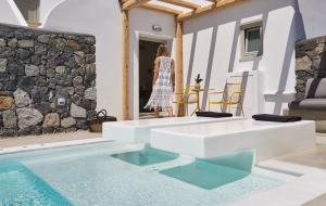 a woman standing in front of a house with a swimming pool at Altera Pars Suites in Mesaria