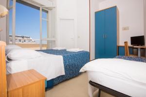 een hotelkamer met 2 bedden en een raam bij Hotel Golf in Cattolica