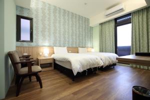 1 dormitorio con cama, escritorio y silla en Dongmen Small Stack, en Hualien City