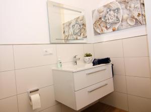 een badkamer met een wastafel en een spiegel bij Haffmuschel in Zirchow