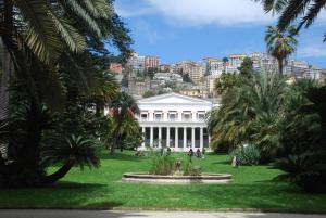 a white house with palm trees in front of it at Base Napoli Mergellina in Naples