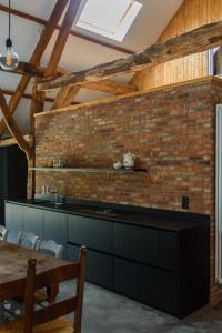 カステルレーにあるVakantieschuur Boerenzwaluwのレンガの壁とテーブル付きのキッチン