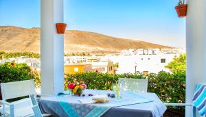 a table with a bowl of fruit on a balcony at Casa Cuba in Morro del Jable +5 photos