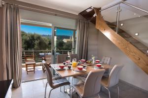 une salle à manger avec une table, des chaises et un escalier dans l'établissement Summer Dream Lefkas, à Leucade