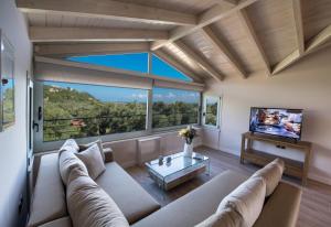 a living room with a couch and a tv at Summer Dream Lefkas in Lefkada Town