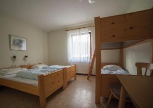1 Schlafzimmer mit 2 Etagenbetten und einem Tisch in der Unterkunft Ferienhaus Vulkaneifel Kopp in Kopp
