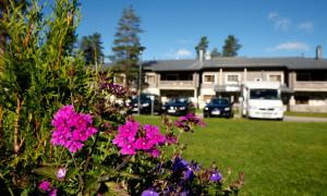 una casa con coches aparcados en un patio con flores en Levi Hotel Spa, en Levi