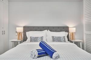 a bedroom with a large white bed with blue pillows at Palm Cove Paradise - Couples spa beach getaway in Palm Cove