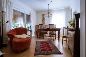 sala de estar con silla roja y mesa en Tektona "Bed & Breakfast" en Nidda