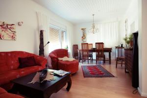 een woonkamer met een rode bank en een tafel bij Tektona "Bed & Breakfast" in Nidda