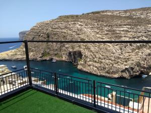 a balcony with a view of a body of water at Avalon seaside studios - Gozo Bellevue Homes in Xlendi