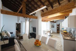 a kitchen and living room with a table and chairs at Casa Higuerón in Seville