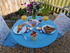 a blue table with breakfast food and orange juice at Dolly at Lowlands in Ringwood +28 photos