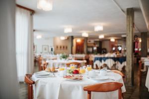 uma mesa com pratos de comida e copos de sumo de laranja em Hotel Argentina em Grado