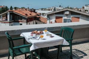una mesa con un plato de comida y bebida en el balcón en Hotel Argentina, en Grado