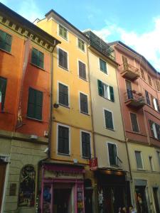 un bâtiment jaune avec des fenêtres dans une rue dans l'établissement Torre Scola, à La Spezia