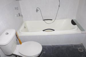 a bathroom with a toilet and a bath tub at Red Roof Farmhouse in Chiplun +18 photos