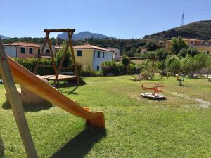 a playground with a slide and a swing at Sardegna Costa Nord Ovest in Santa Maria