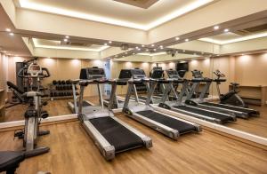 a gym with several treadmills and elliptical machines at Athens Avenue Hotel in Athens