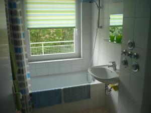 a white bathroom with a sink and a window at Haus Marinus in Puttgarden +82 photos