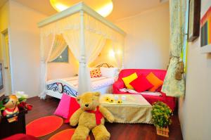 um urso de peluche sentado numa sala com um quarto em Smile Orange Homestay em Dongshan