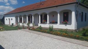 ein kleines weißes Gebäude mit Blumen davor in der Unterkunft Heni Vendégháza in Vadna