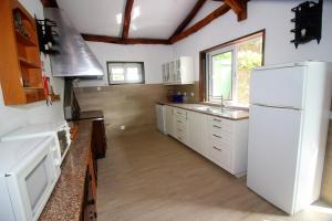 a kitchen with white appliances and a white refrigerator at Casa da Verdasca by Gerês Casas in Geres