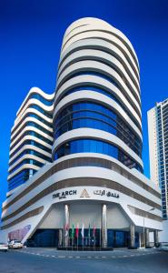 a large white building with a sign on it at Arch Hotel in Manama