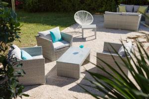 een patio met banken, een tafel en een stoel bij Kyriad Montpellier Est - Lunel in Lunel