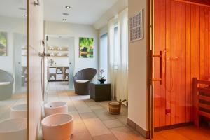 a bathroom with four sinks and a row of toilets at H+ Hotel Zürich in Zürich