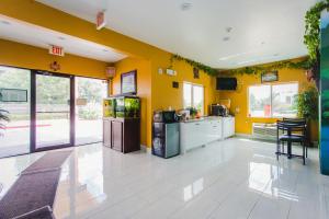 a kitchen with yellow walls and a white floor at Moonlight Suites - Houston/George Bush Int'l Airport in Houston